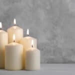 Set of white candles over grey stone background with copy space